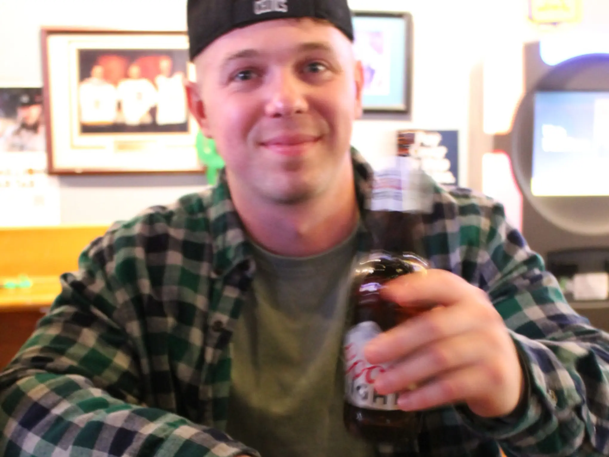 man drinking coors light at bar