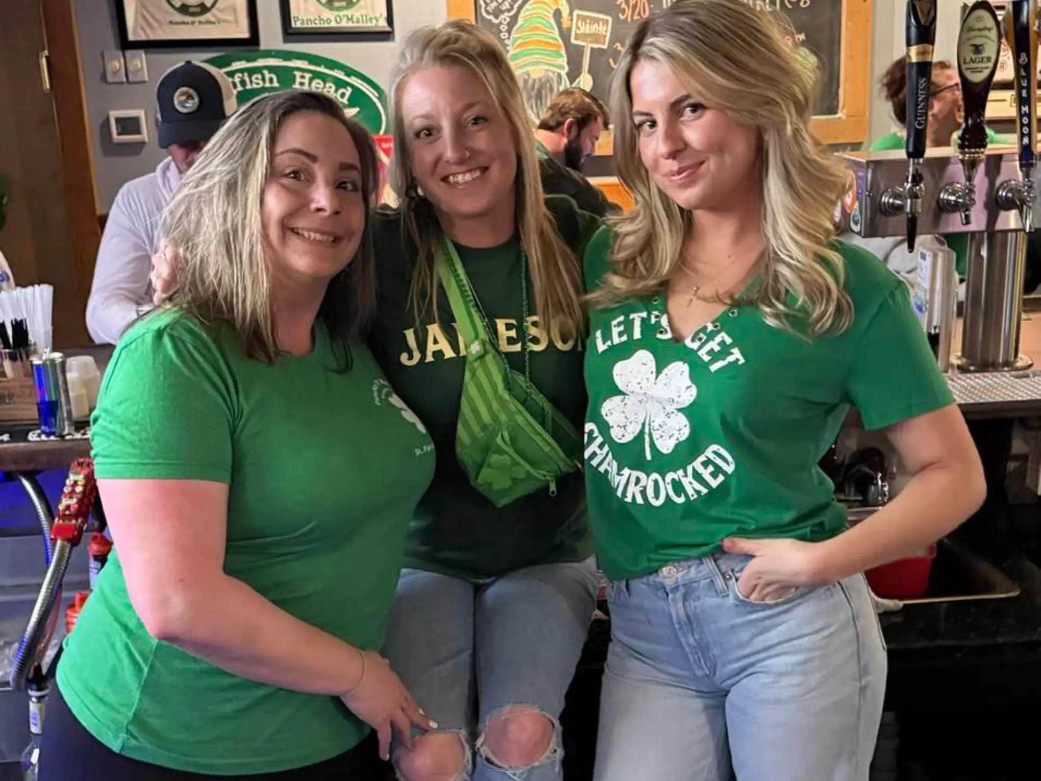three ladies serving drinks behind the bar. pancho's, st. patrick's day 2026